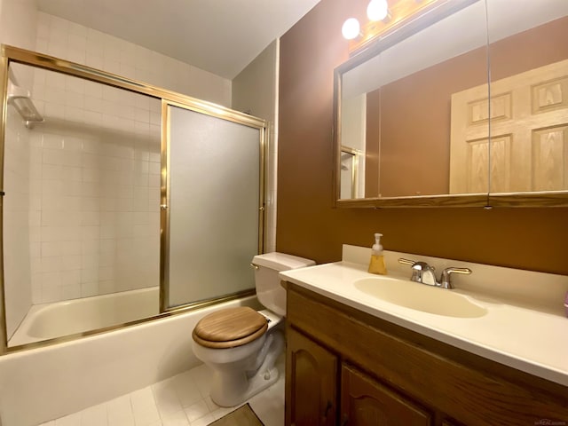 bathroom with vanity, toilet, bath / shower combo with glass door, and tile patterned flooring