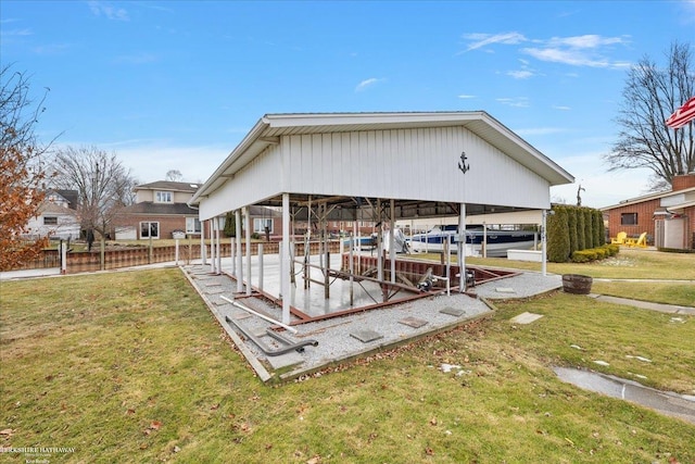 back of property featuring fence, a yard, and boat lift
