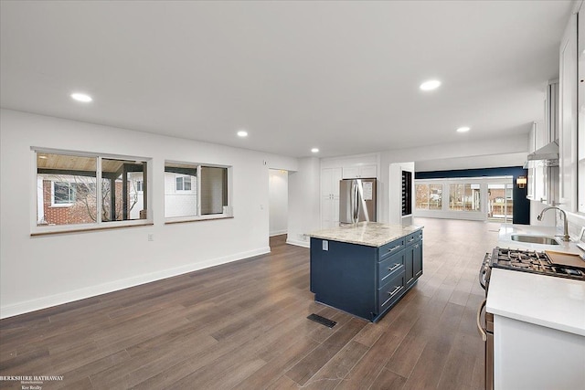 kitchen featuring dark wood-style floors, a sink, light countertops, and freestanding refrigerator