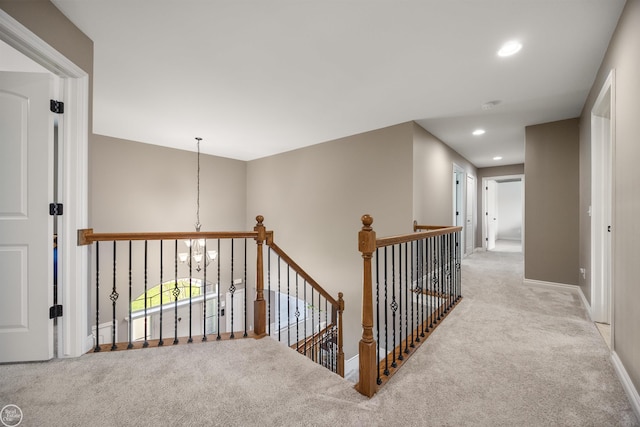 corridor featuring baseboards, carpet flooring, an upstairs landing, and recessed lighting