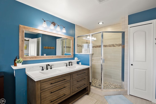 full bath with a shower stall, a sink, and double vanity