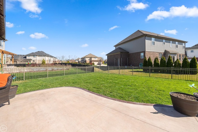 view of yard featuring a fenced backyard, a residential view, and a patio