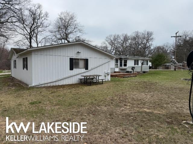 back of property with a lawn and a deck
