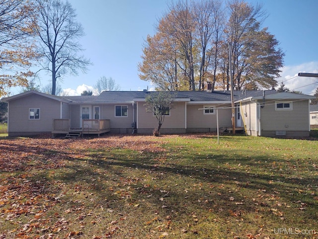 rear view of house featuring a yard and a deck