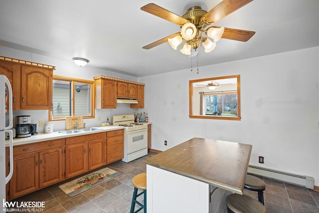 kitchen with a baseboard heating unit, a sink, gas range gas stove, a ceiling fan, and under cabinet range hood