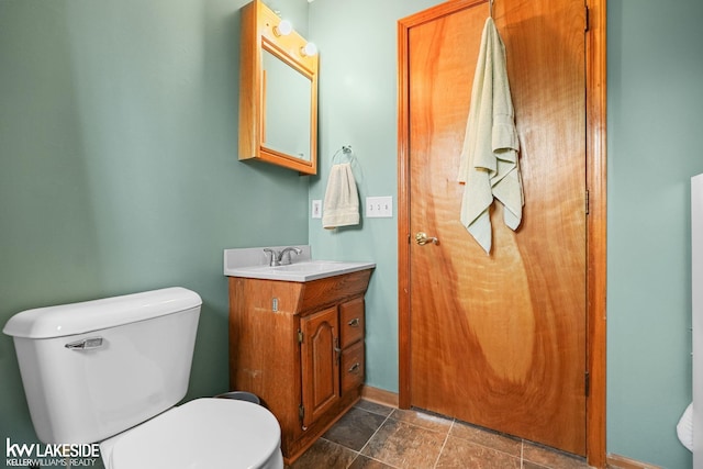 half bathroom featuring vanity and toilet