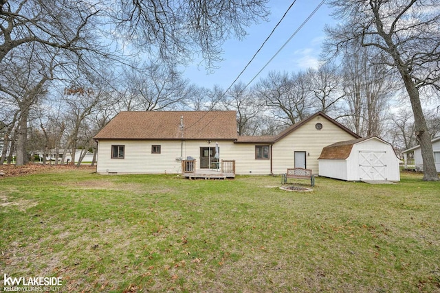 back of house featuring a wooden deck, a storage unit, a yard, and an outbuilding