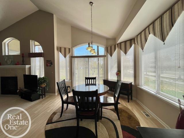 dining room featuring baseboards, light wood-style floors, and visible vents