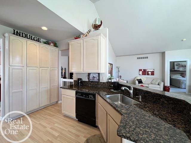 kitchen with dark stone countertops, visible vents, a sink, light wood-type flooring, and black dishwasher