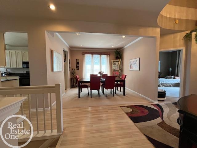 dining room with baseboards, recessed lighting, light wood-style floors, and ornamental molding
