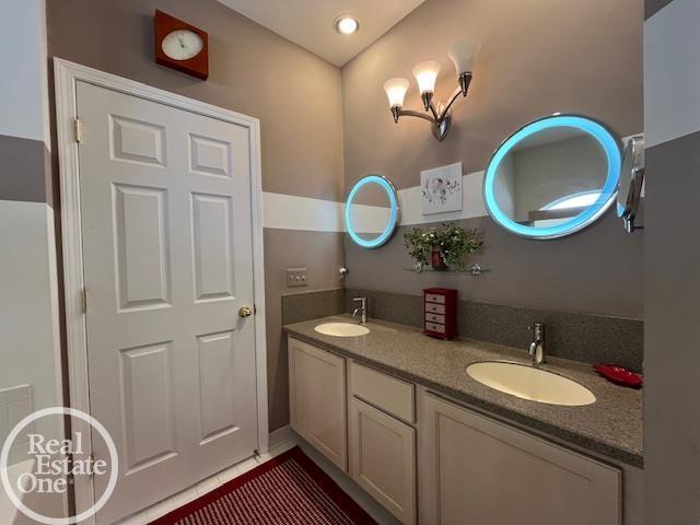 bathroom with tile patterned flooring, a sink, recessed lighting, and double vanity