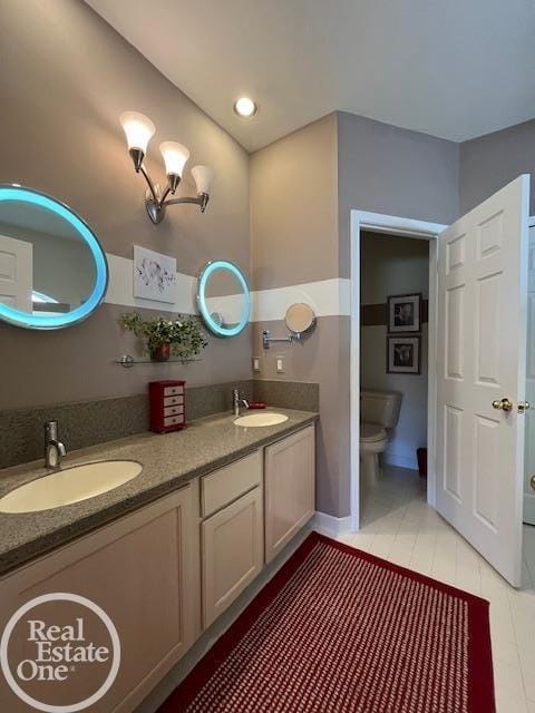 bathroom with toilet, tile patterned flooring, a sink, and double vanity