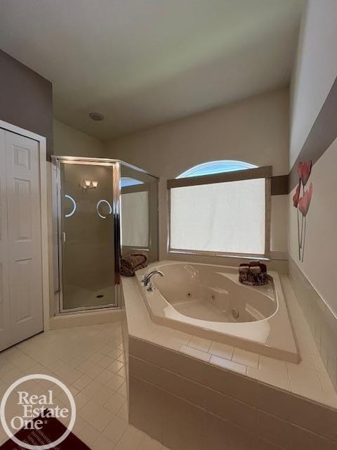 bathroom with a jetted tub, tile patterned flooring, and a shower stall
