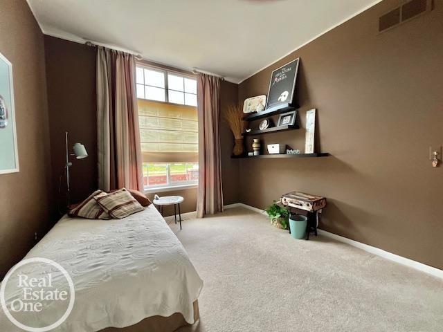 bedroom featuring carpet floors, visible vents, and baseboards