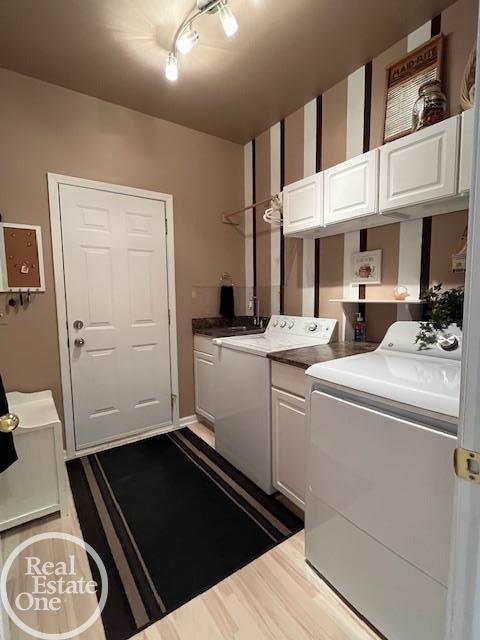 clothes washing area featuring washer and dryer, dark wood-style flooring, and cabinet space