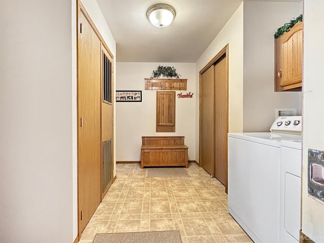washroom featuring baseboards, washer and dryer, and cabinet space