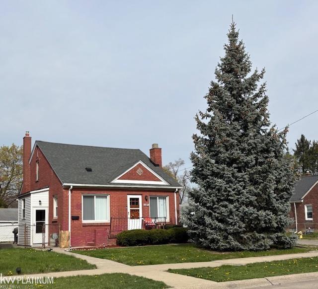 20845 Universal Ave, Eastpointe, MI 48021 - view of front of house featuring a chimney, brick siding, and roof with shingles