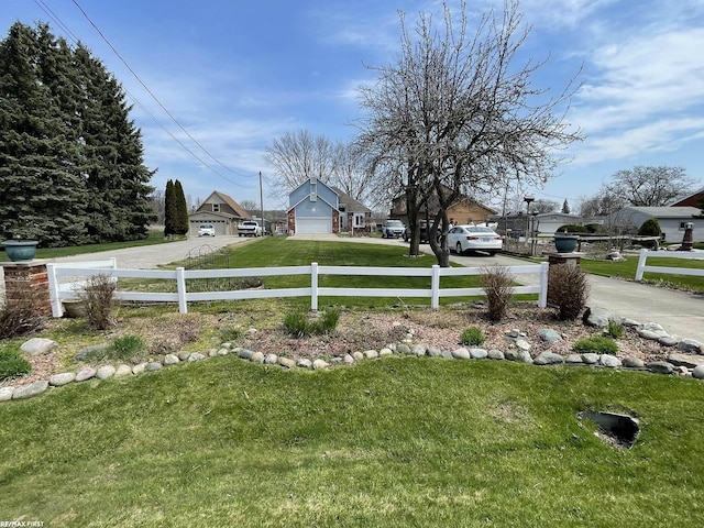 view of yard featuring fence and driveway