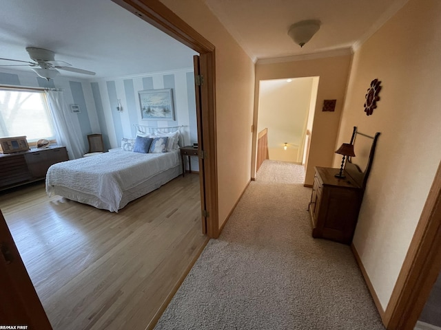 bedroom featuring light wood-style floors, ceiling fan, baseboards, and ornamental molding