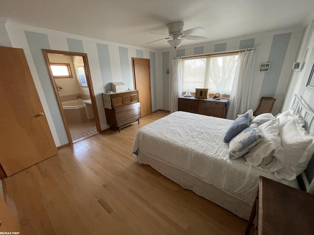 bedroom featuring ensuite bath, light wood-style floors, ceiling fan, and crown molding