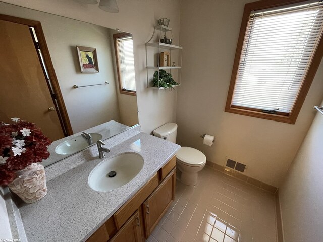 bathroom featuring visible vents, tile patterned floors, vanity, and toilet