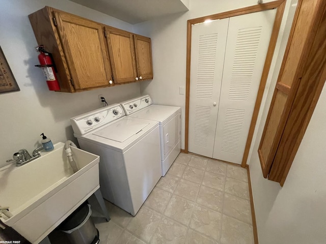 laundry area with cabinet space, a sink, and separate washer and dryer