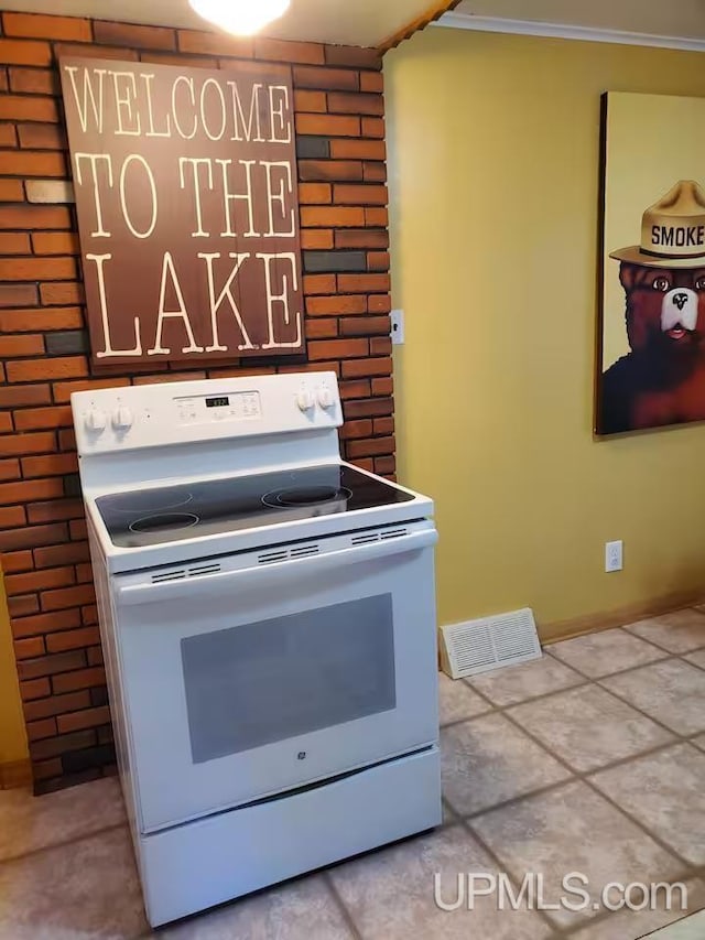 kitchen featuring ornamental molding, baseboards, visible vents, and electric stove