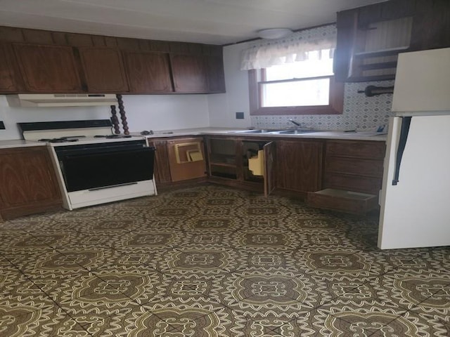 kitchen featuring light countertops, a sink, under cabinet range hood, and white range with electric stovetop