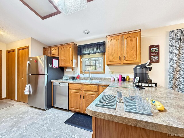 2709 W 6th Ave, Gladstone, MI 49837 - kitchen featuring light countertops, appliances with stainless steel finishes, brown cabinets, and a sink