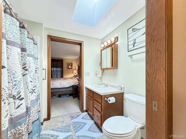 2709 W 6th Ave, Gladstone, MI 49837 - ensuite bathroom featuring a skylight, connected bathroom, vanity, toilet, and a shower with shower curtain