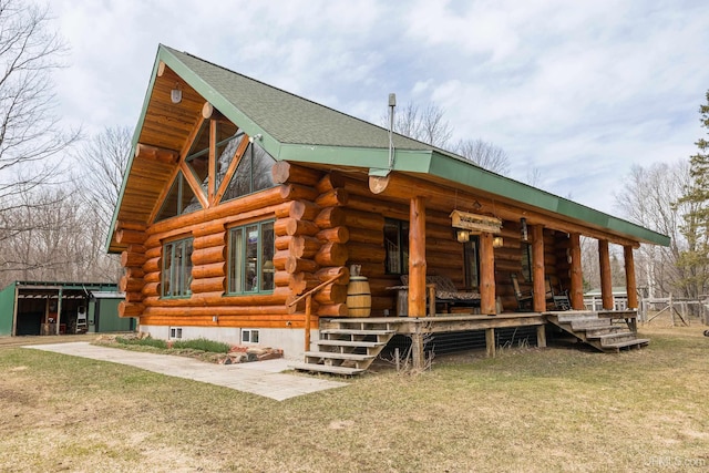 exterior space featuring a lawn, covered porch, and log siding