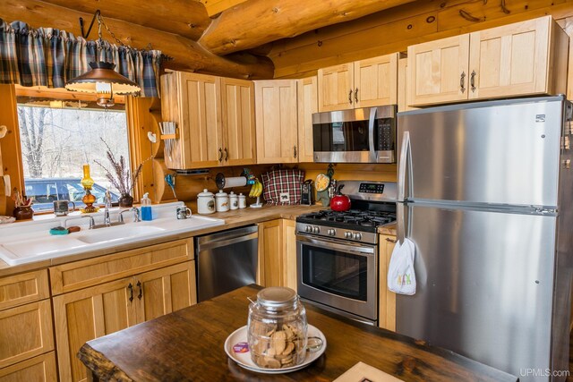 kitchen featuring light brown cabinets, a sink, and appliances with stainless steel finishes