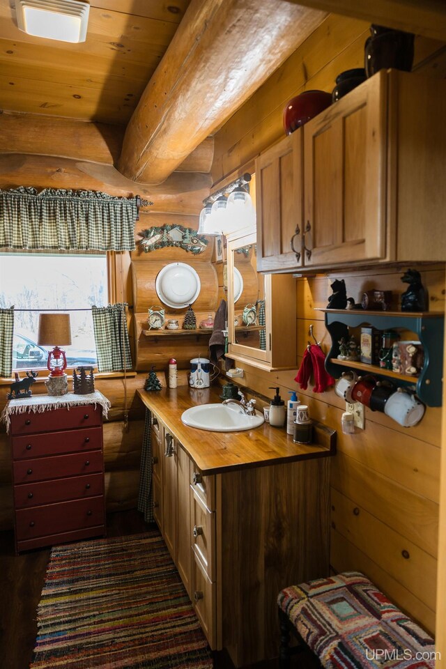 bathroom featuring wood ceiling, vanity, and rustic walls