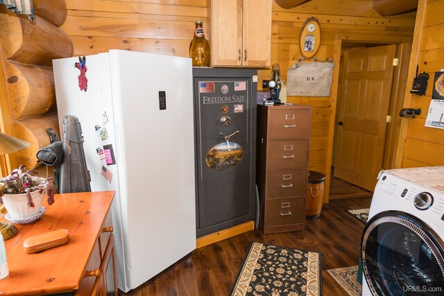 laundry room with washer / dryer, wooden walls, dark wood-style flooring, and laundry area