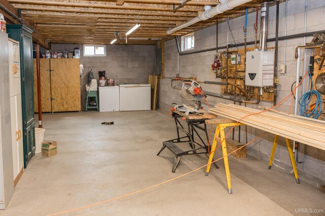 below grade area with refrigerator, a workshop area, and electric panel