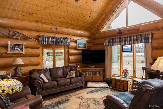 living area featuring plenty of natural light, log walls, wood finished floors, and high vaulted ceiling