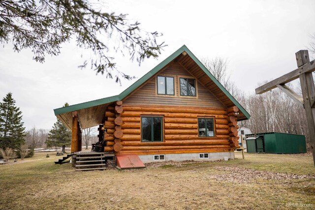 rear view of house featuring an outdoor structure and log exterior