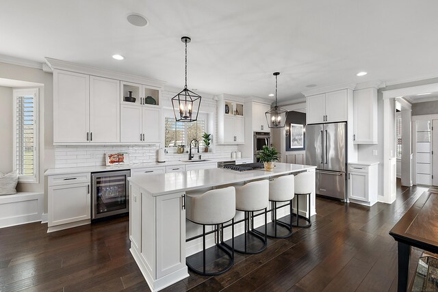 kitchen with a center island, beverage cooler, stainless steel appliances, and recessed lighting