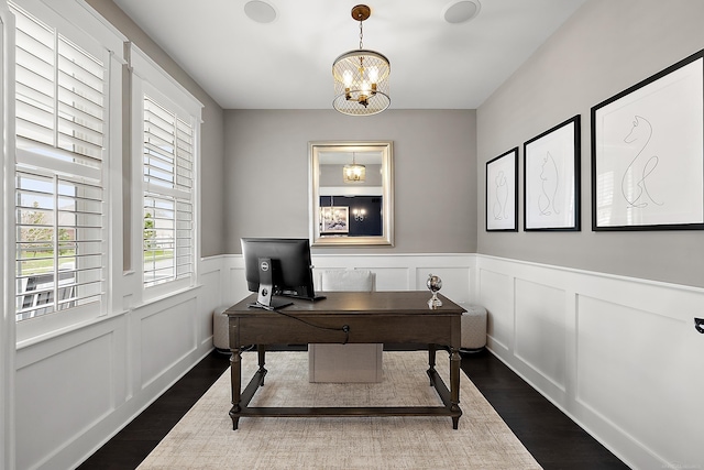 office with a wainscoted wall, an inviting chandelier, a decorative wall, and dark wood finished floors