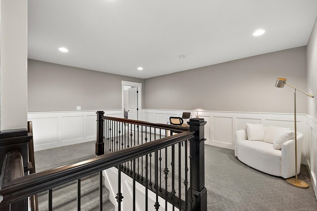 hallway featuring recessed lighting, carpet floors, a wainscoted wall, and an upstairs landing