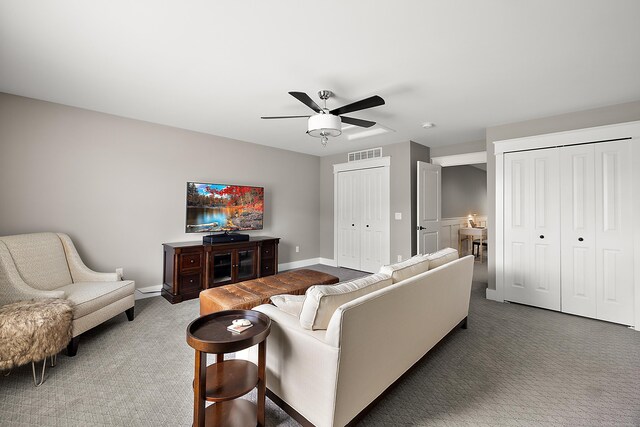 carpeted living room with baseboards, a ceiling fan, and visible vents