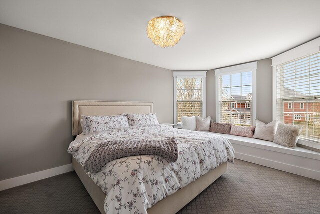 carpeted bedroom featuring baseboards and multiple windows