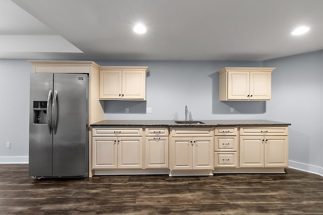 kitchen featuring a sink, stainless steel fridge, baseboards, recessed lighting, and cream cabinets
