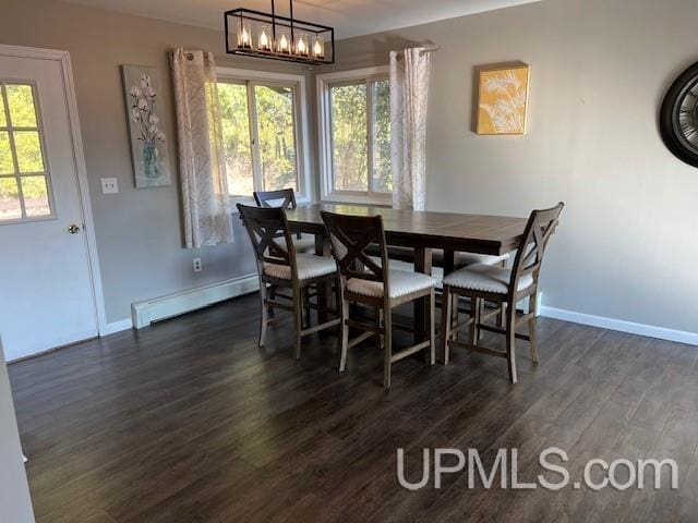 dining area with a baseboard heating unit, dark wood-style floors, a wealth of natural light, and a notable chandelier