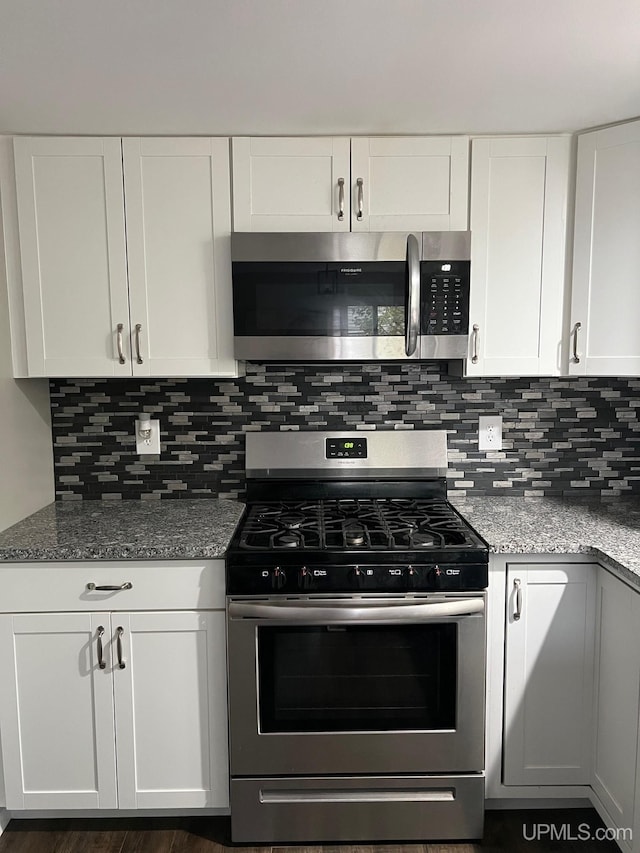 kitchen featuring tasteful backsplash, stone counters, white cabinetry, and stainless steel appliances
