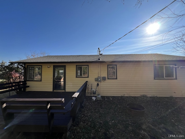 back of house with a shingled roof and a deck