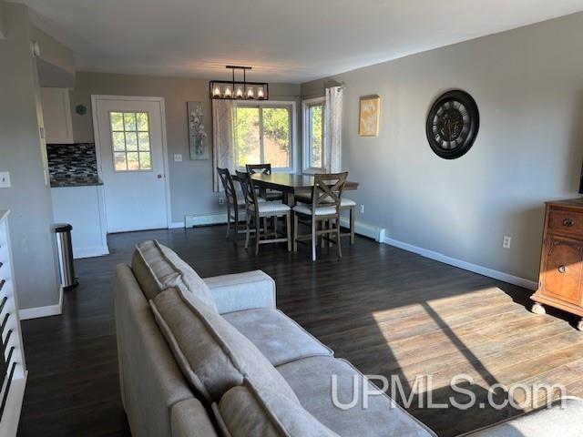 living area with baseboards and dark wood finished floors