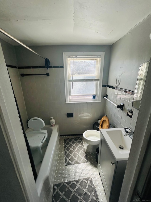 bathroom with toilet, tile walls, tile patterned flooring, and vanity