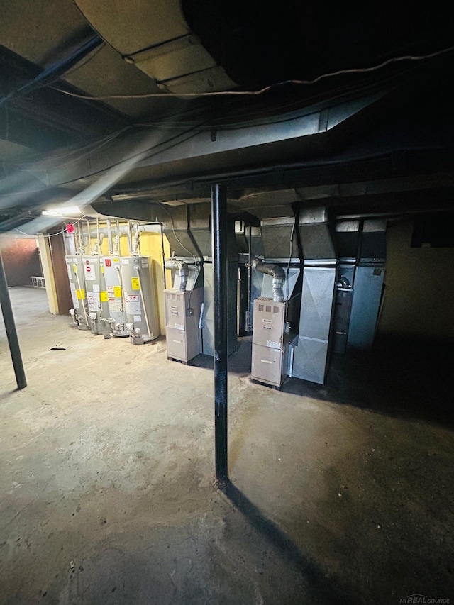 unfinished below grade area featuring water heater, heating unit, and gas water heater