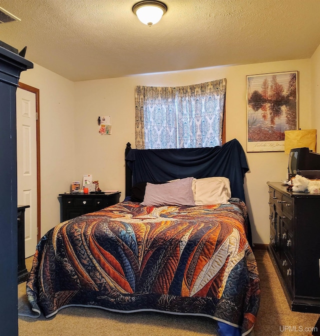 carpeted bedroom with a textured ceiling and visible vents